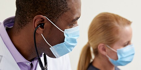 Closeup of clinician with stethoscope in ears
